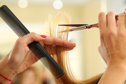 Female hairdresser hold in hand between fingers lock of blonde hair, comb and scissors closeup. Keratin restoration, latest trend, fresh idea, haircut picking, shorten tips, instrument store concept